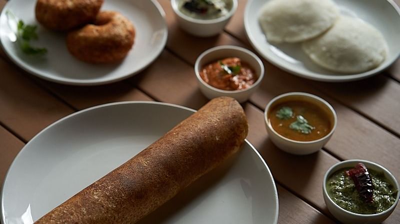A plate of masala dosa accompanied by different chutney, a plate of idili, and a plate of vada at The Hamuse Hotel, Kodaikanal.