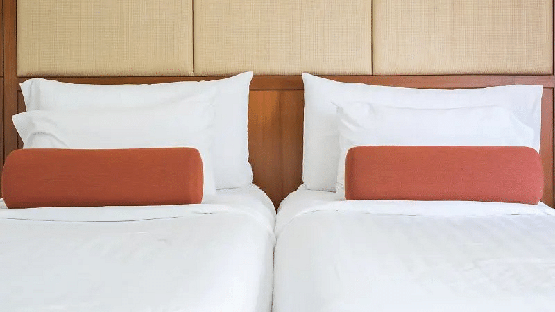 An image of a twin bed with neatly arranged mattress and pillows