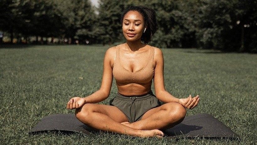 A meditating woman sitting on a Yoga mat