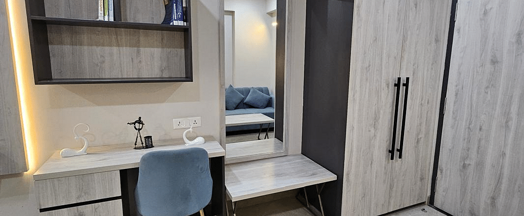A view of the reading table placed against the wall, with a mirror and a cupboard beside it at Urban Suites by BluSalzz, Jaipur.