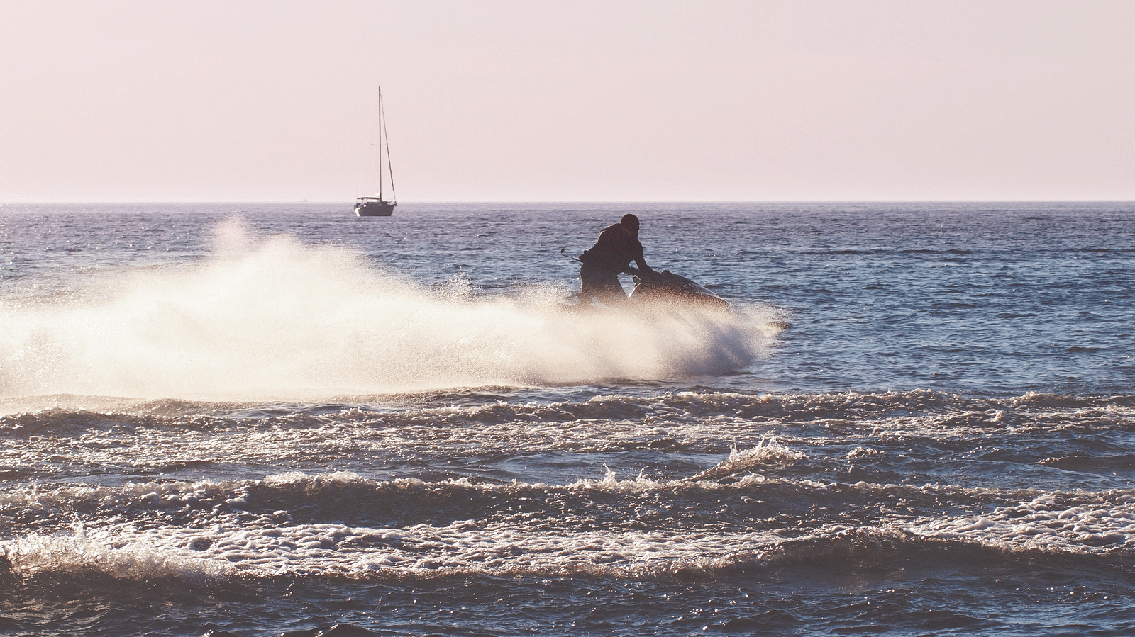 A person gliding across the beach on a jet ski