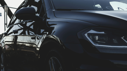 Close-up of a black car with reflective bodywork and modern detailing.