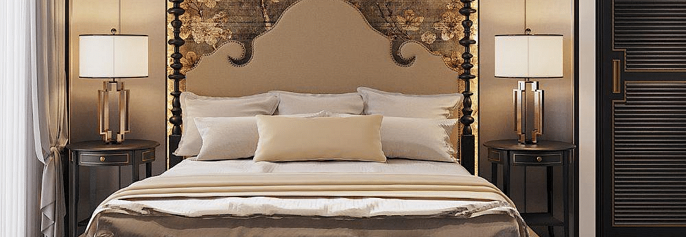 Front view of a well-made bed with cushions, a ceiling fan, and two bedside tables with lamps at The Evren, Vagator.