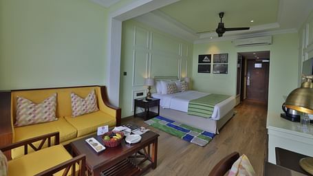 Standard Tropic Green Room with Partial Mountain View room with comfortable seating, dining area, and cozy ambiance at Fragrant Nature Munnar