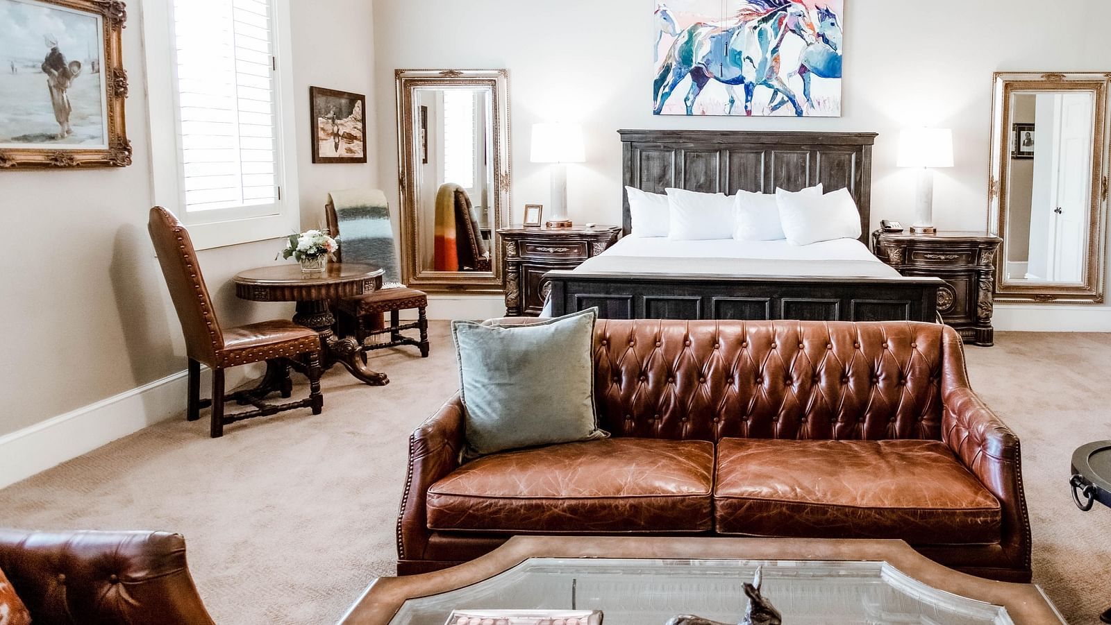 A luxurious bedroom featuring a leather sofa, wooden furniture, and stylish accents, designed for comfort and sophistication - The Grand Hotel & Ballroom, McKinney