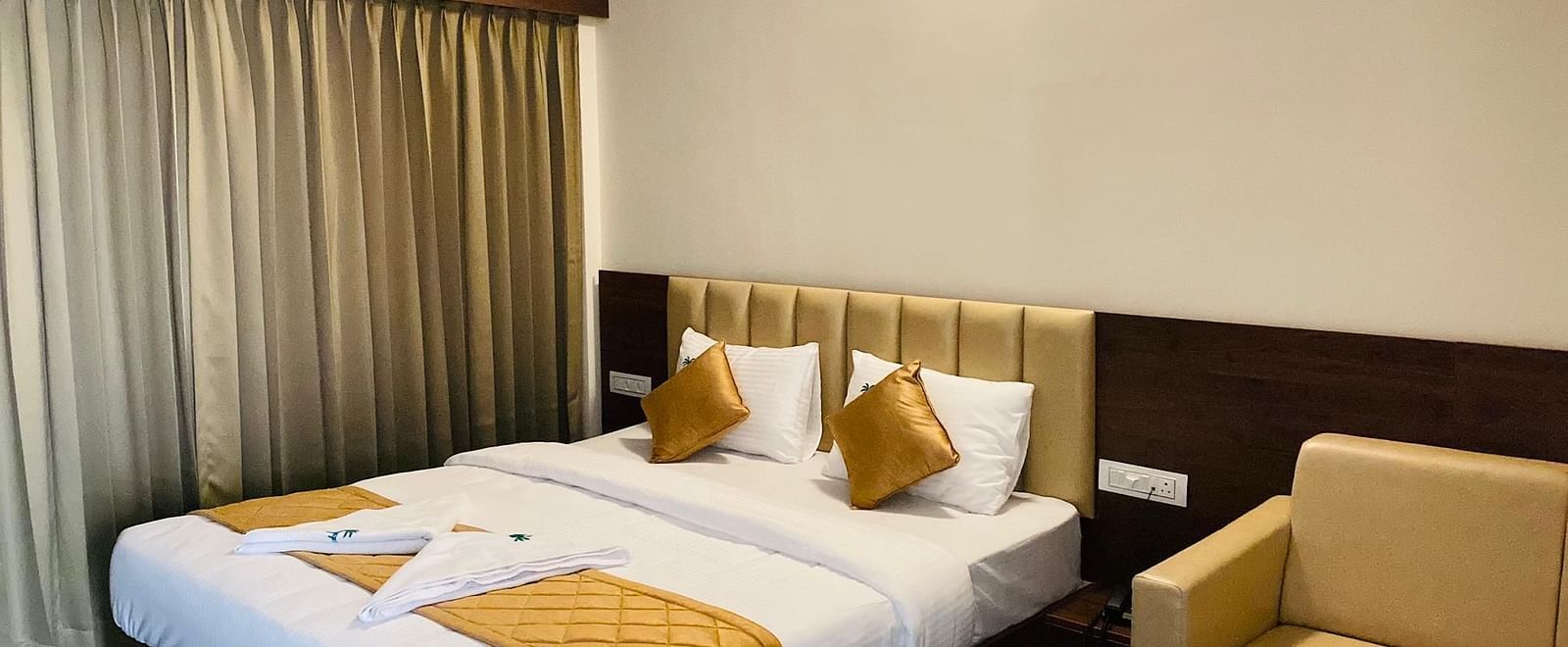 Room featuring twin beds, golden pillows, and stylish drapery for a restful stay at Hotel Sahara Tree.