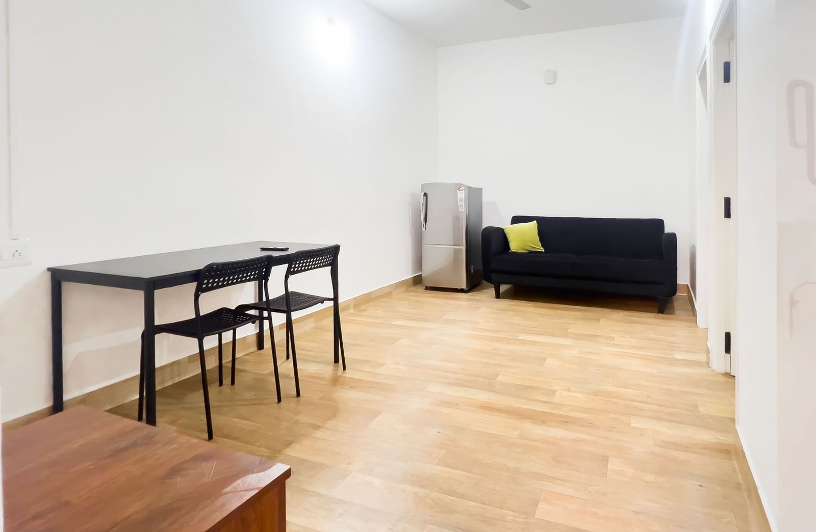 Open-plan living room with sofa, table, and wooden floor at The Pinnacle, Electronic City.