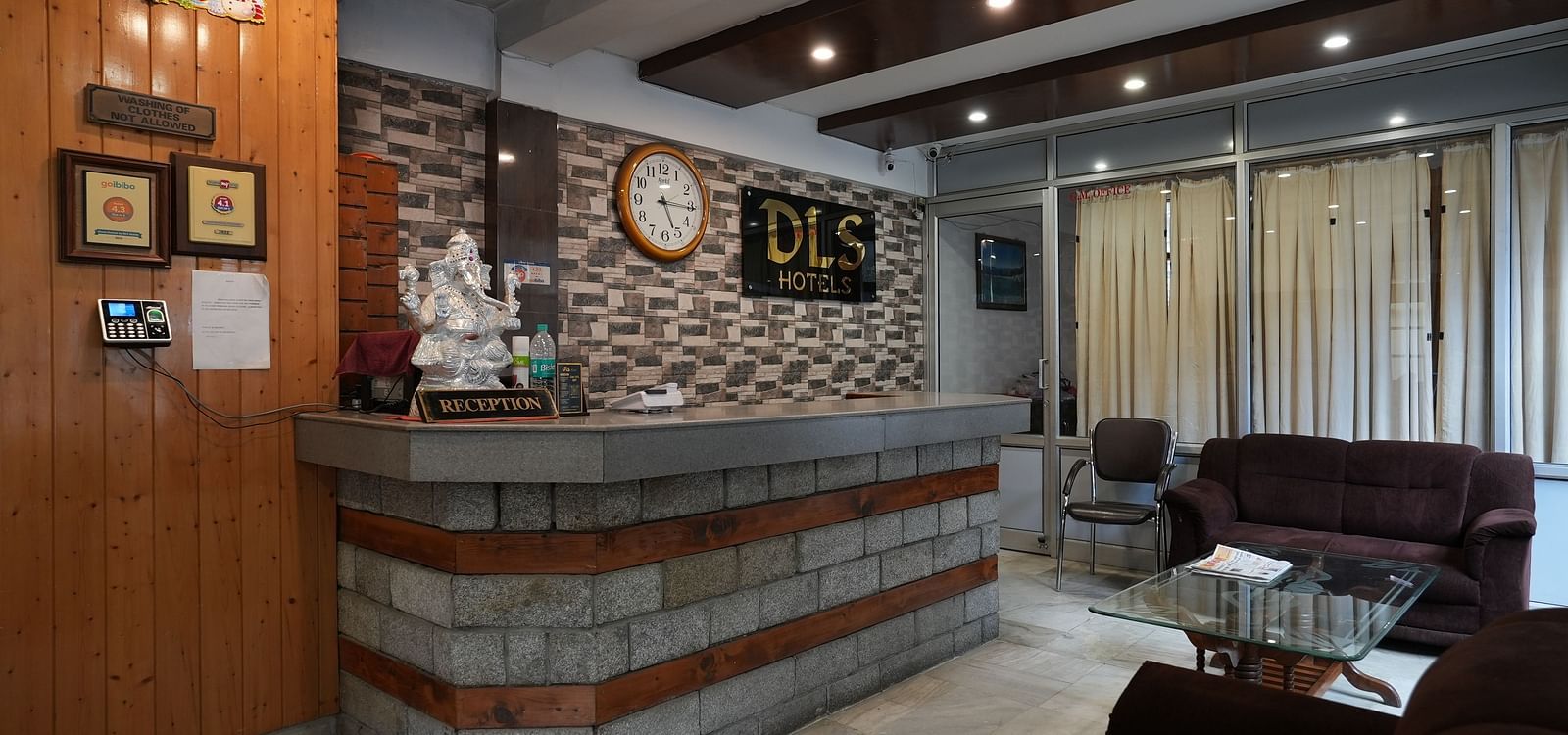  A welcoming hotel reception area with a wooden counter, warm lighting, and a comfortable seating arrangement.