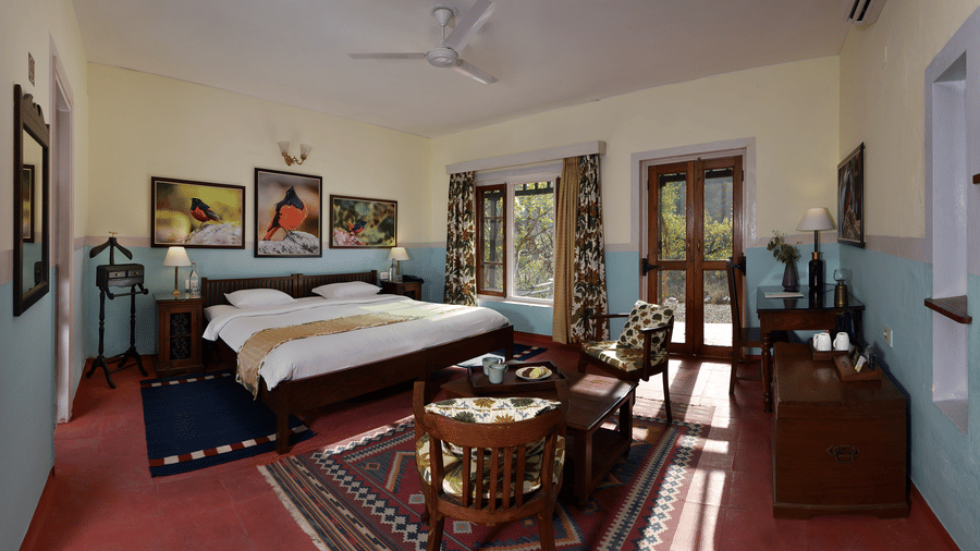 Expansive heritage suite bedroom with classic furnishings spacious layout and warm tones offering a premium accommodation experience at Neemrana’s Glasshouse on The Ganges suitable for guests seeking space and tranquillity