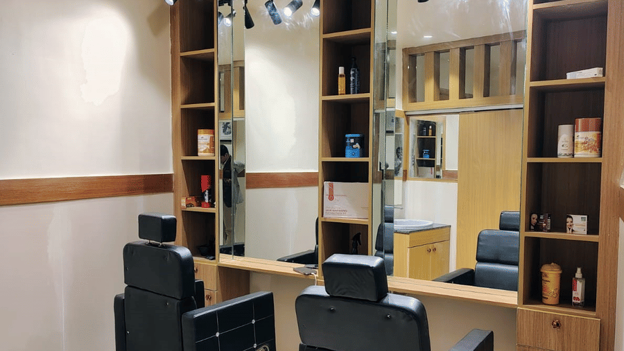 A salon at ABN Sarovar Portico, Jim Corbett featuring two chairs in front of the mirror, and behid the mirrors there are shelves where all the cosmetic products are kept. 