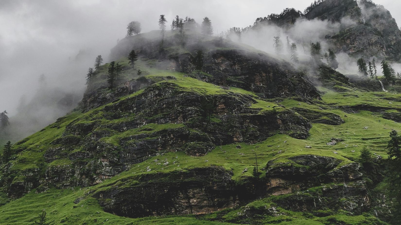 A green mountain under a misty sky.