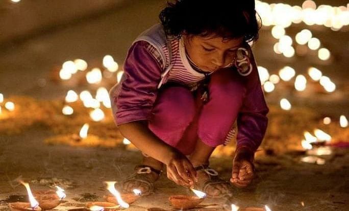 A young girl lighting diyas for the Diwali festival