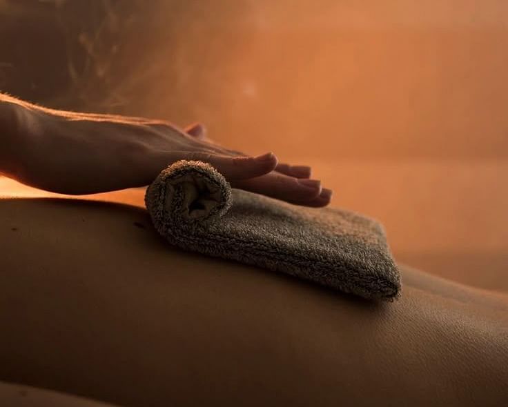 Close-up of a back massage in progress under warm, ambient lighting.