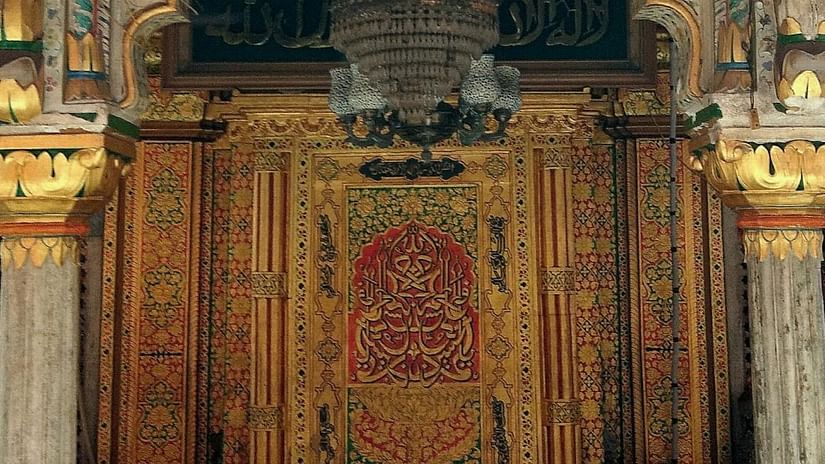 image of an entrance to a mosque chamber with intricate carvings, golden accents, and a large central panel adorned with Islamic calligraphy - The Dukes Retreat, Khandala