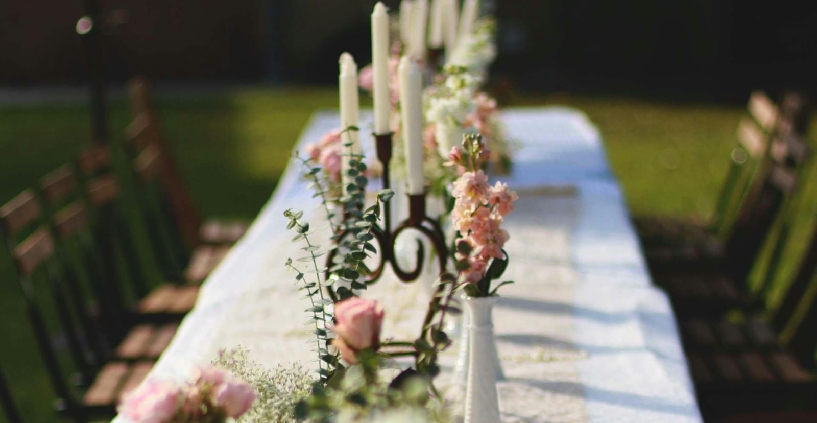 A beautifully set long table with white flowers and candles, ready for an event at the Tallman Hotel.