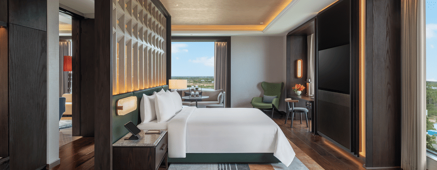 Presidential Suite Room 8001 master bedroom with a bed and warm ambient lighting at The Residency Signature Madurai.