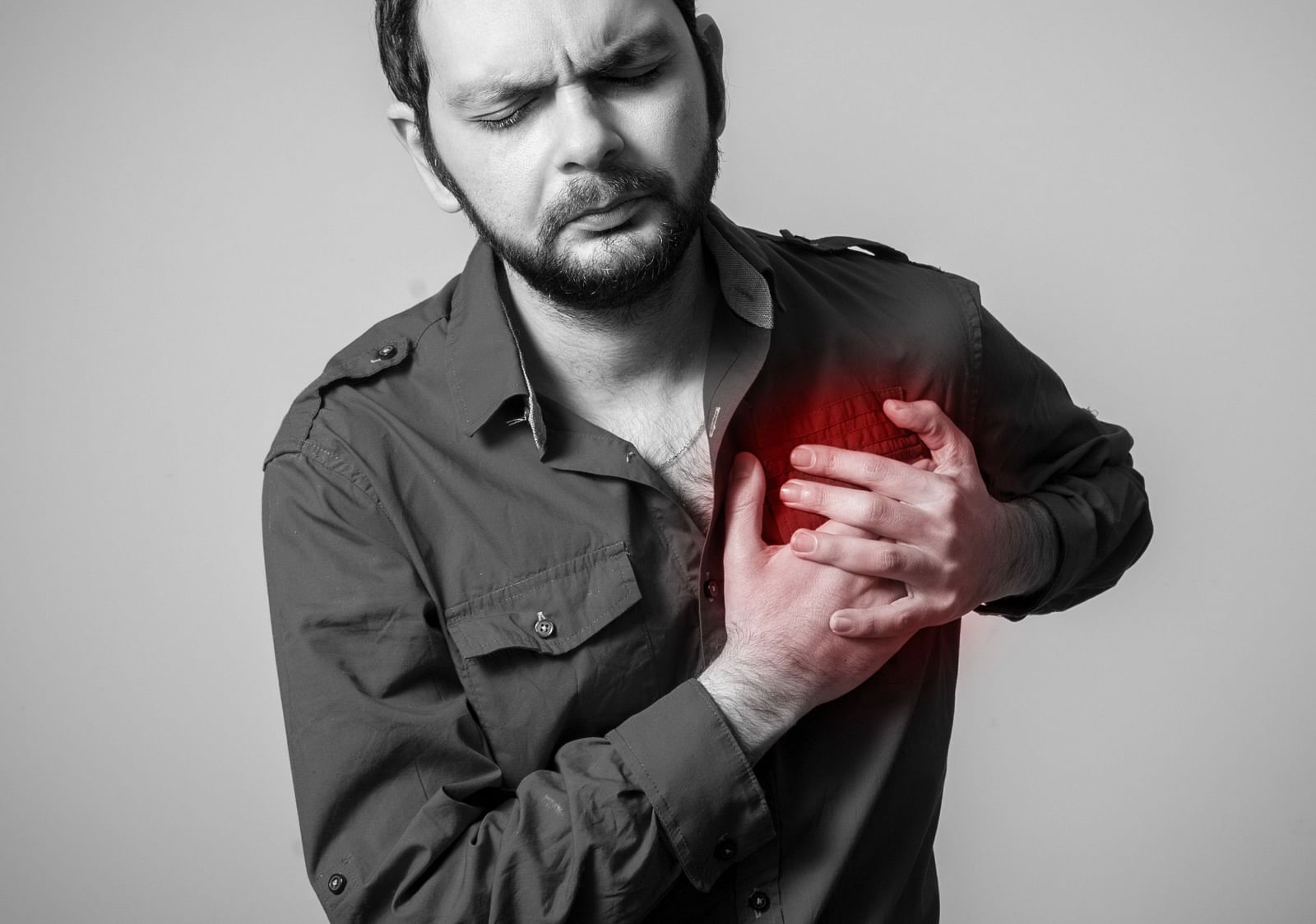 A man clutching his chest, experiencing chest pain - Shreyas Retreat