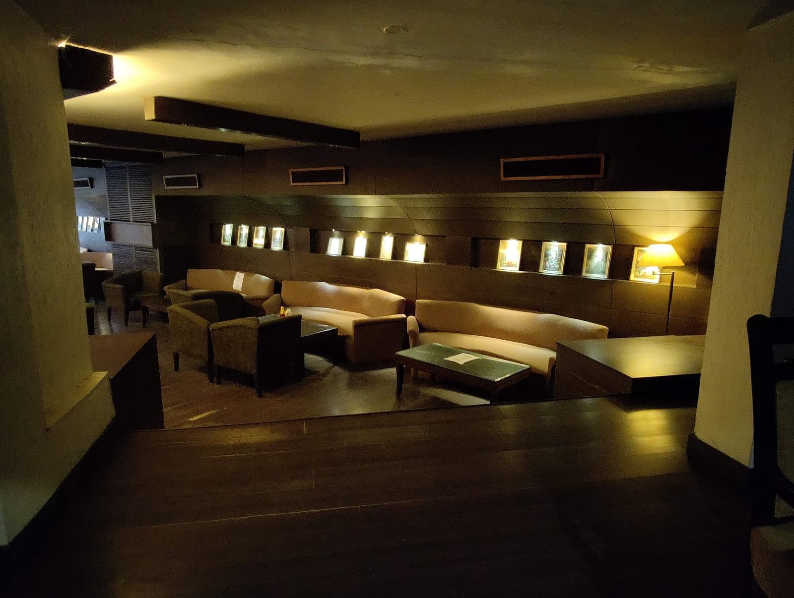 A dimly lit indoor seating area at 24 Karats bar - Hotel Gold, Panipat