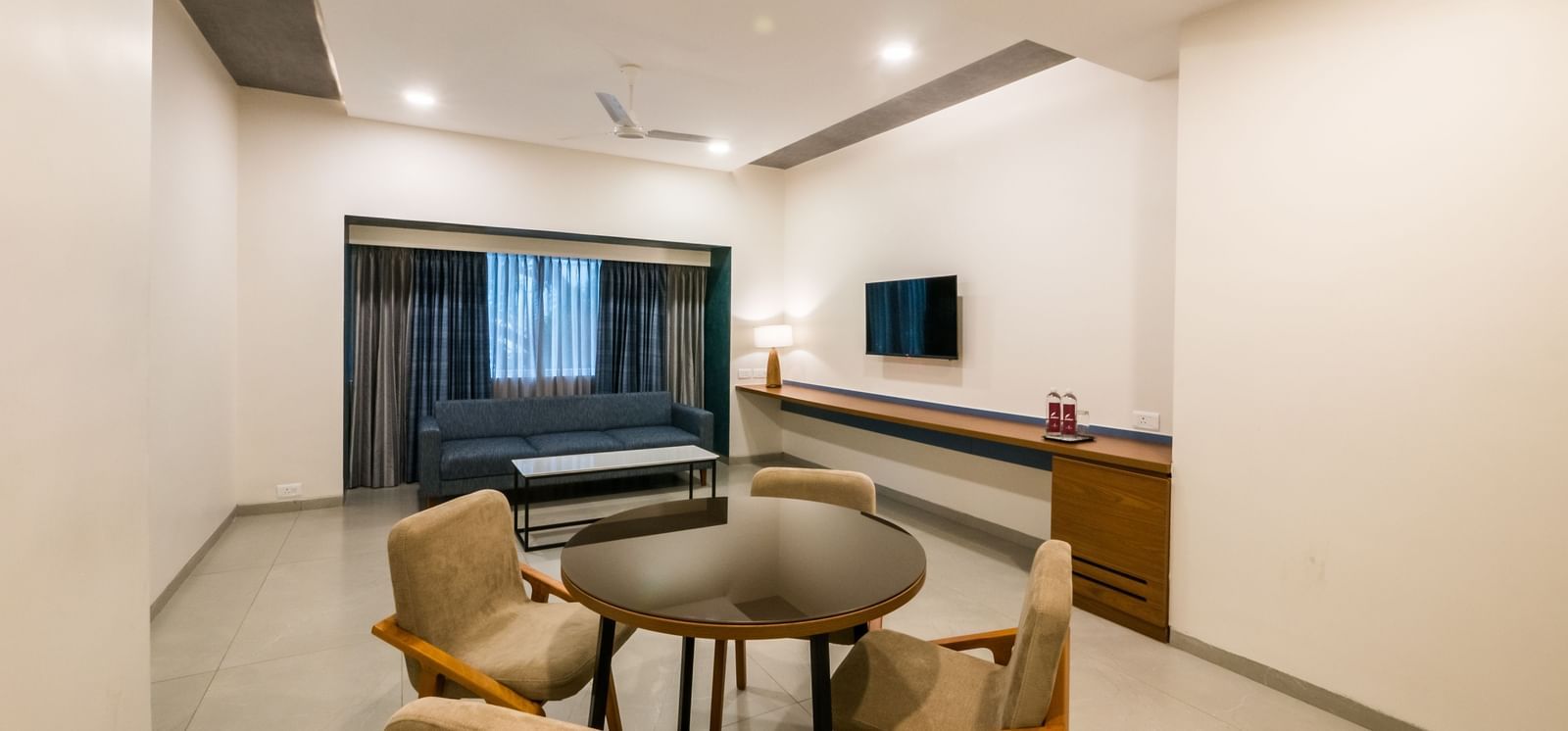  A hotel living area with a round dining table and chairs, perfect for meals or work at Shilton Dee Cee.