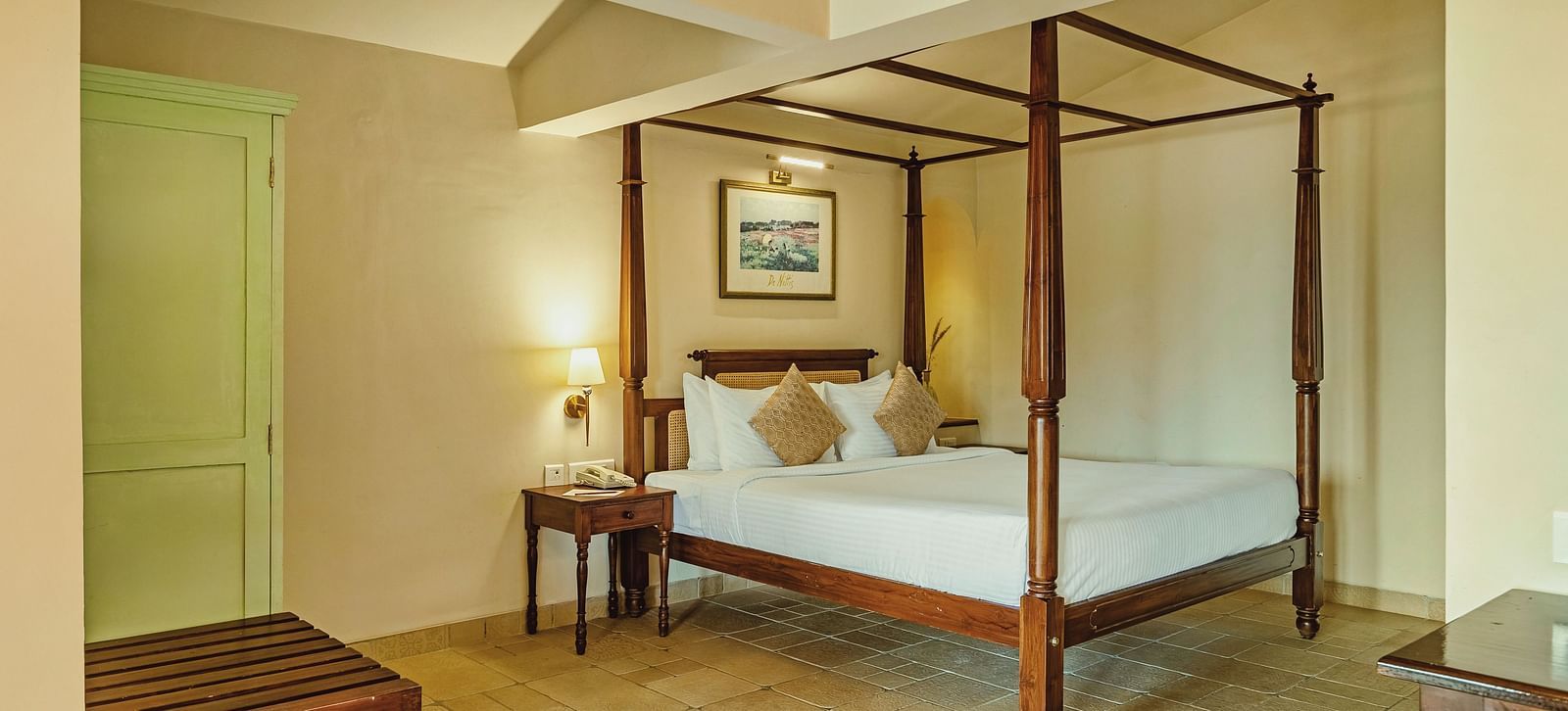 A bedroom at Mango Hill Shola, Ooty featuring a four-poster bed, wooden bench, and soothing lighting