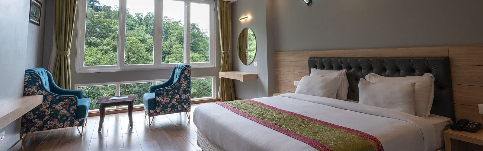 Image of Executive Room featuring a plush bed and a seating space next to a large window