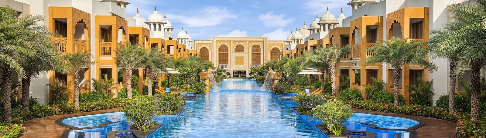 A stunning wide-angle view of our palace, with a grand central pool framed by exquisite buildings of Rajasthani architecture on both sides - Kaldan Samudhra Palace