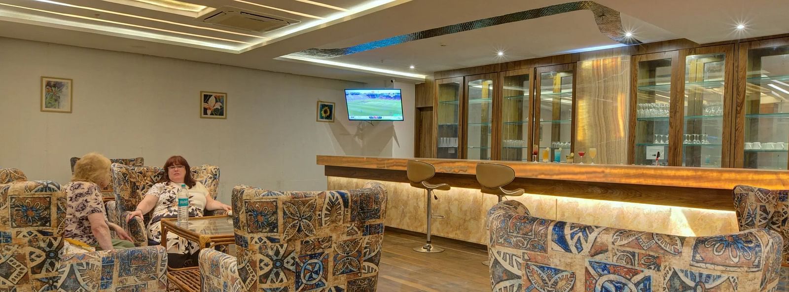A indoor lounge with a patterned seating under a warm lighting.