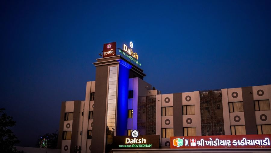 Close-up of the illuminated tower of Daksh The Grand Gowardhan, Dwarka, at night.
