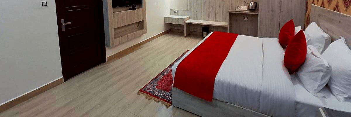 A Premium Room at DLS Nature Trinket Resort with a king size bed, a television, and a side table.