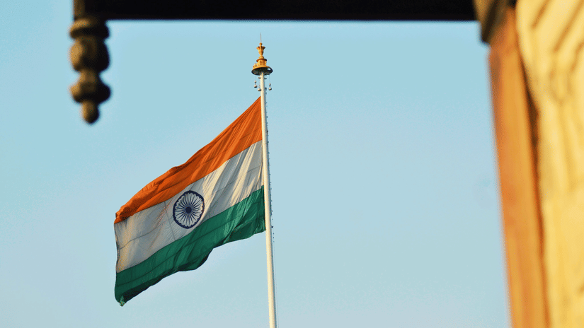 Indian national flag waving against blue sky, symbolising patriotism and the spirit of Independence Day celebrations in India.