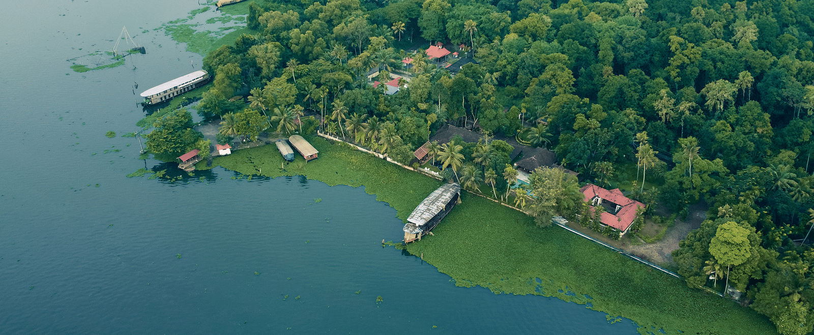 An aerial shot showcasing the Vembanad Lake and the resort surrounded by lush greenery - BluSalzz Villas - Muhamma Resort, Alleppey