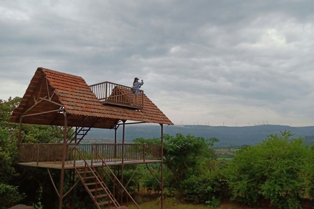 An elevated wooden structure at Forest Escapes Koyna offers panoramic views of the surrounding landscape.