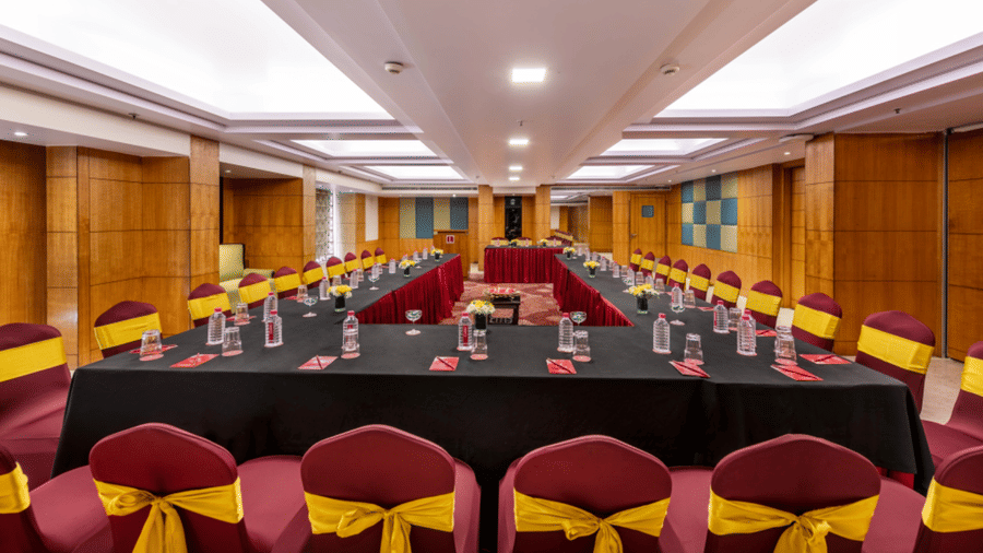 a large boardroom with U-shaped seating arrangements  with wood-panelled walls and ceiling lights at Libra Lords Inn Jaipur
