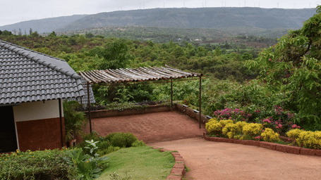Cottage area with tiled roofs and pathway facing hillside view at Forest Escapes.