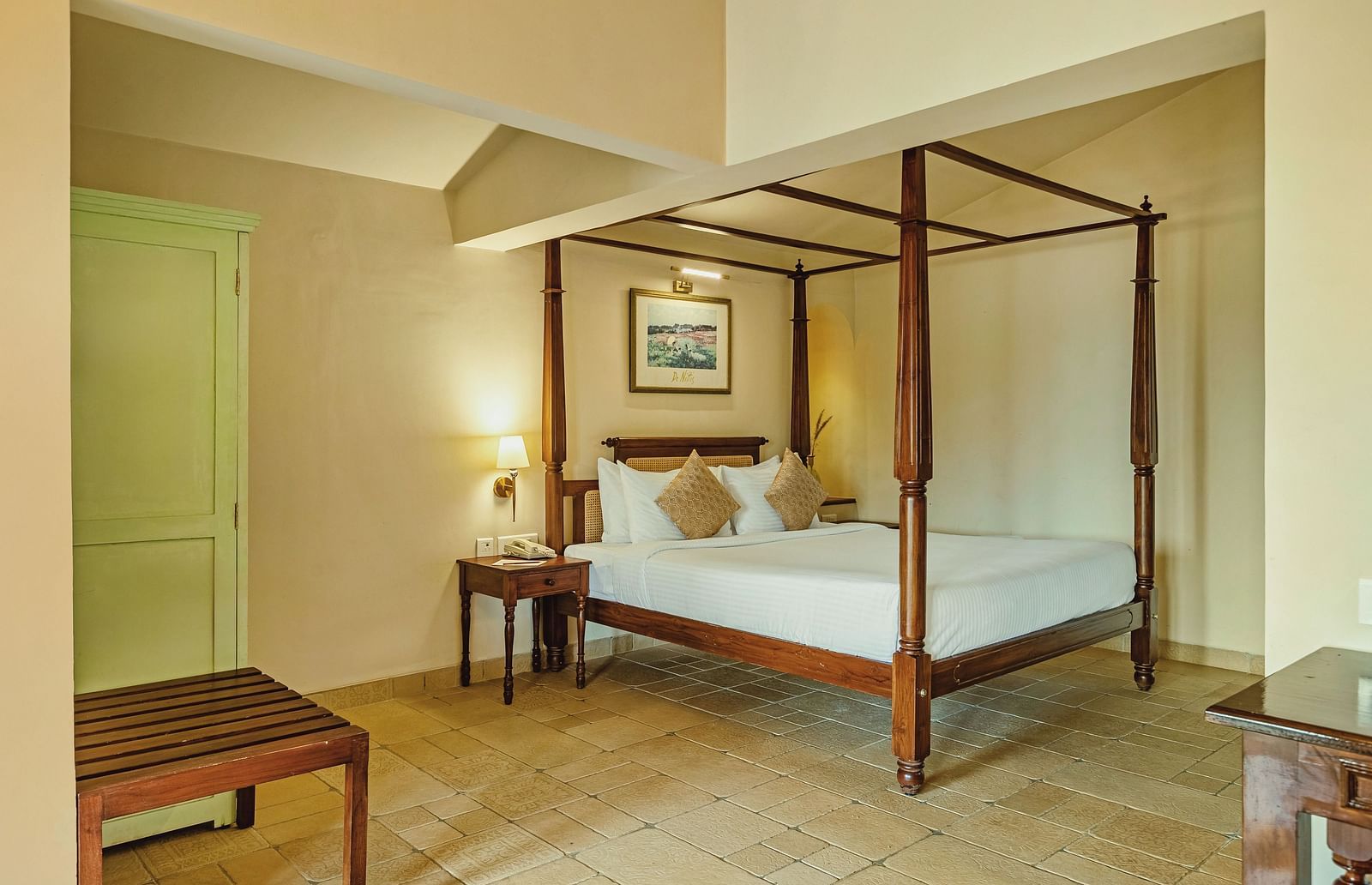 A bedroom at Mango Hill Shola, Ooty featuring a four-poster bed, wooden bench, and soothing lighting