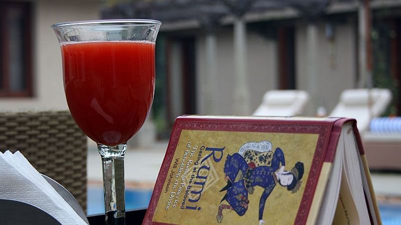 A table set outdoors with a drink, a book with a design - Shreyas Retreat