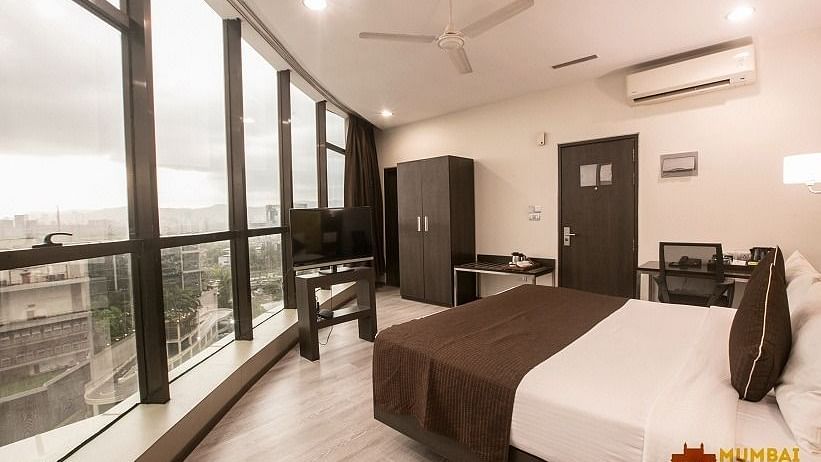 Luxury Room with a double bed and large windows at Hotel Mumbai House, Airoli