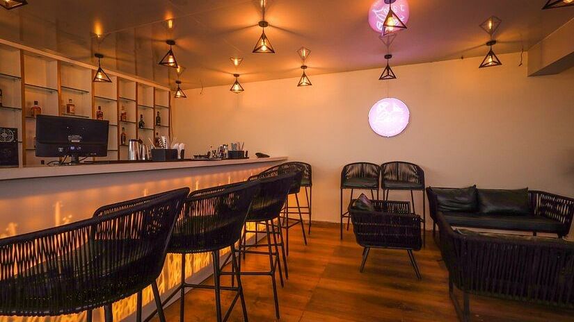 M Cafe with wooden flooring and high chairs lined against the couter table at Vagator Downtown, Goa