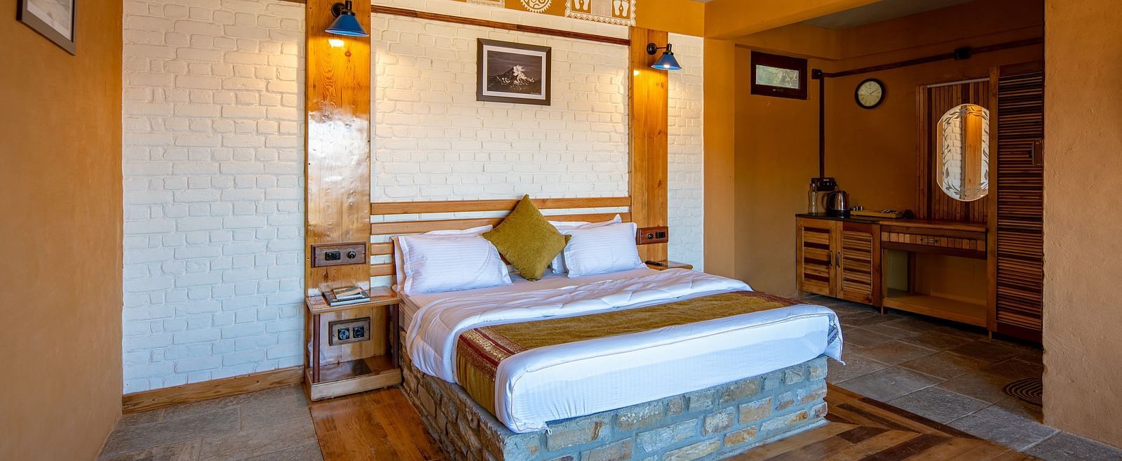Rustic bedroom with a wooden bed, white brick wall, and traditional decor accents. - Blusalzz Homes The Himalayan Bungalow, Almora