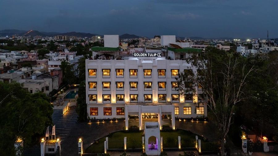 Golden Tulip, Udaipur exterior view with illuminated windows during dusk.