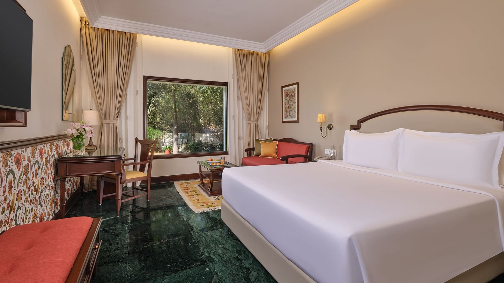 The Premium King Garden View Room at The Ummed Ahmedabad offers a spacious interior with warm lighting and a cozy king size bed