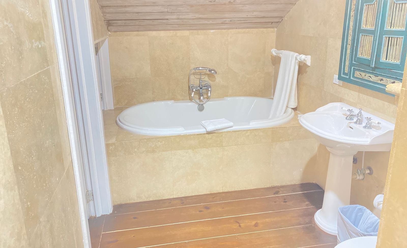 A bathroom with a freestanding bathtub under a sloped ceiling | A Stone's Throw Away
