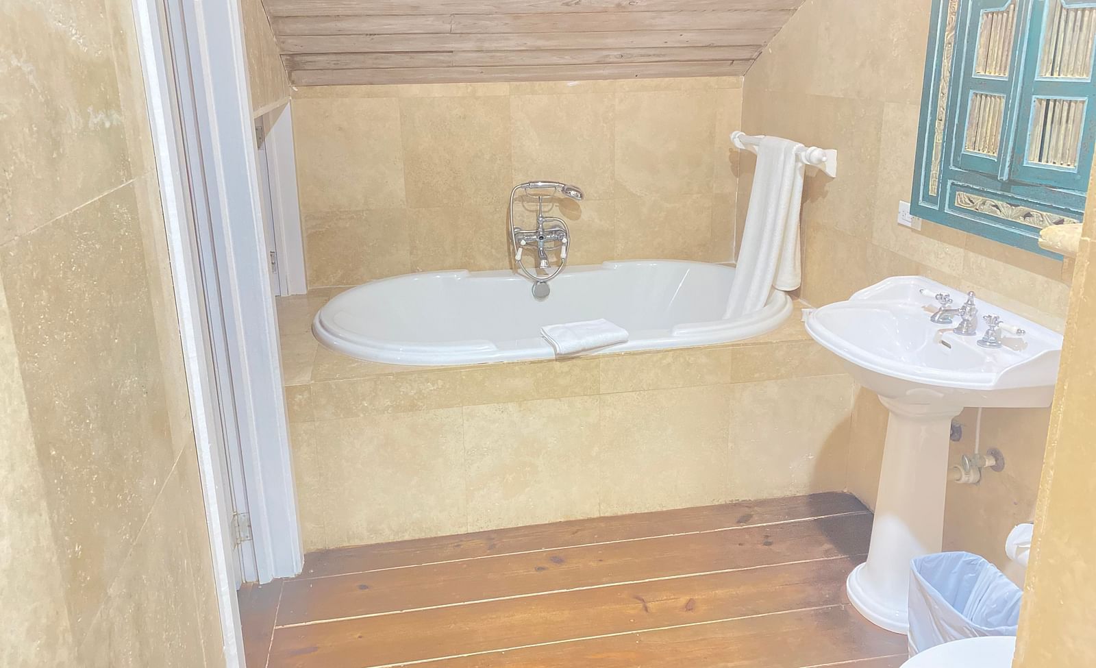 A bathroom with a freestanding bathtub under a sloped ceiling | A Stone's Throw Away