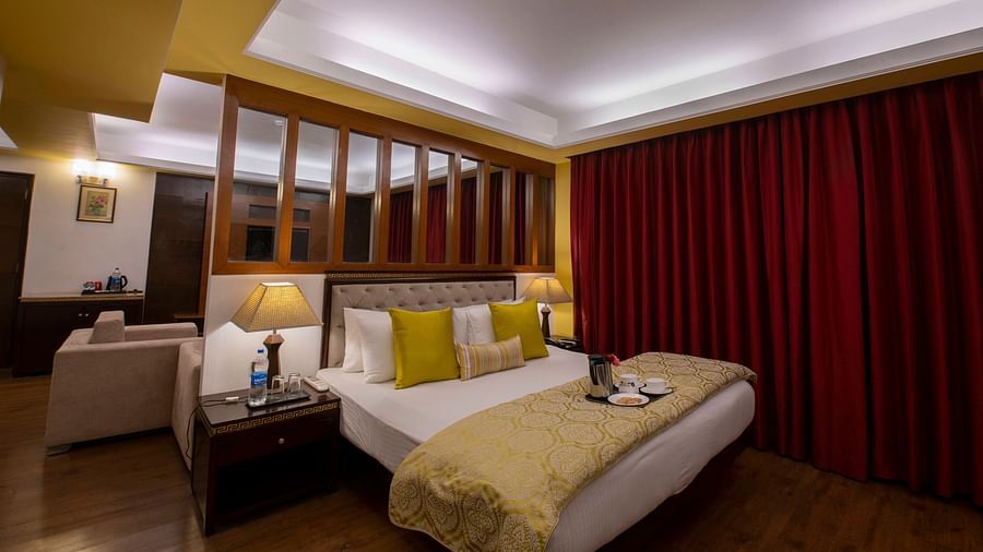a view of a bed in Suite decked with a bed with yellow duvet at Mastiff Grand, Manali