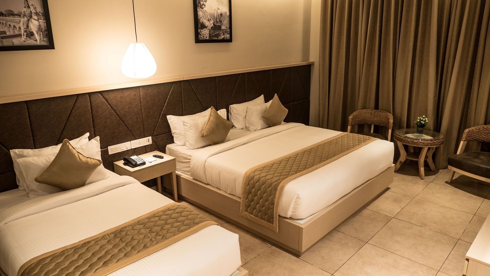 view of a king size bed and a single bed at Executive Tripple Room at Cholaa Dynasty, Kumbakonam