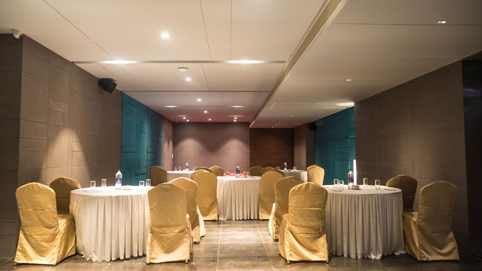 event halls with yellow chairs and white table at Cholaa Dynasty, Kumbakonam