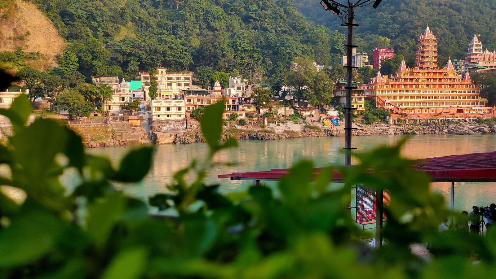 View of a temple facing a river with lush greenery in the background