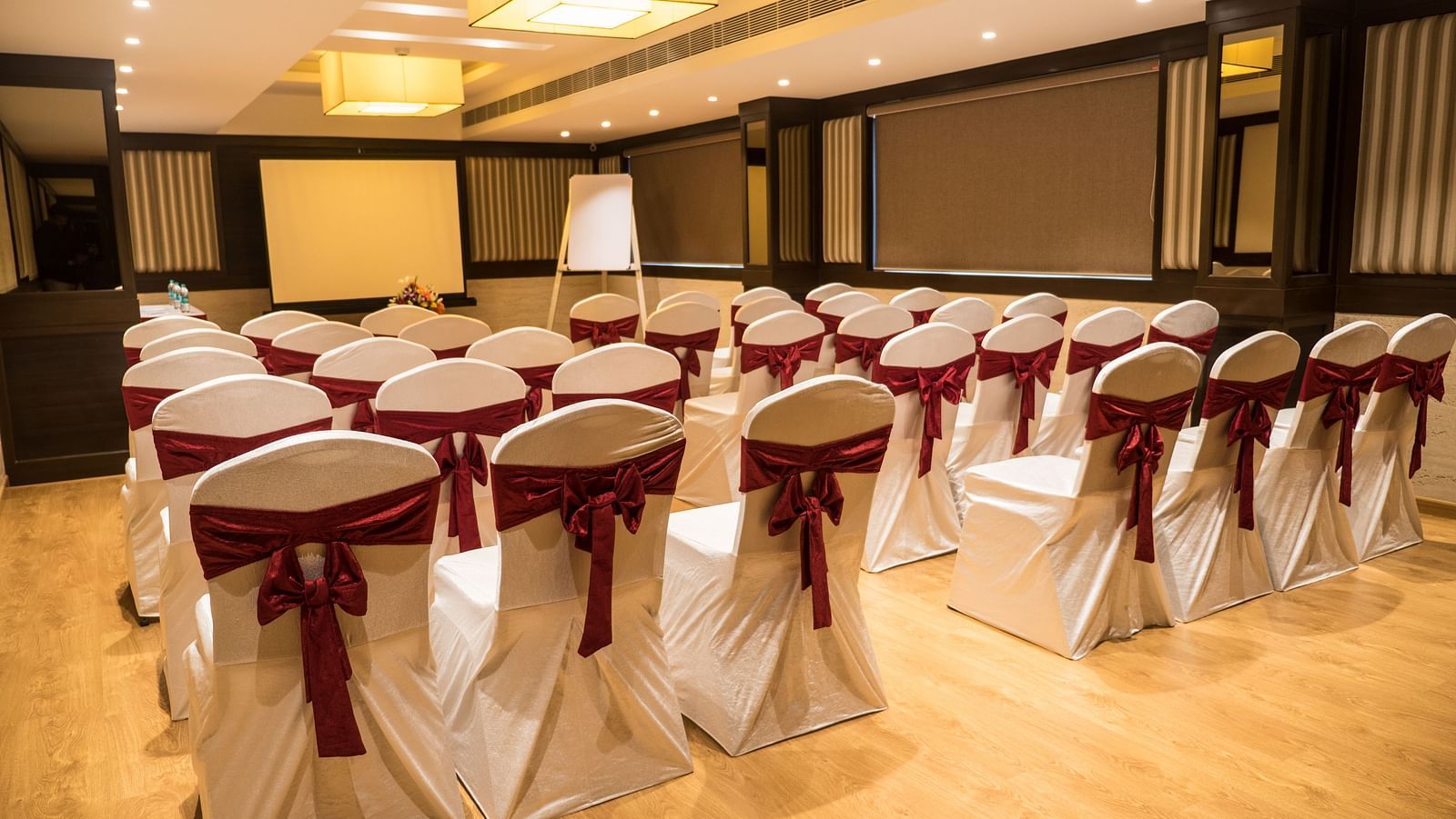 event hall with white satin chair and red ribbon of MM Legacy, Kanchipuram