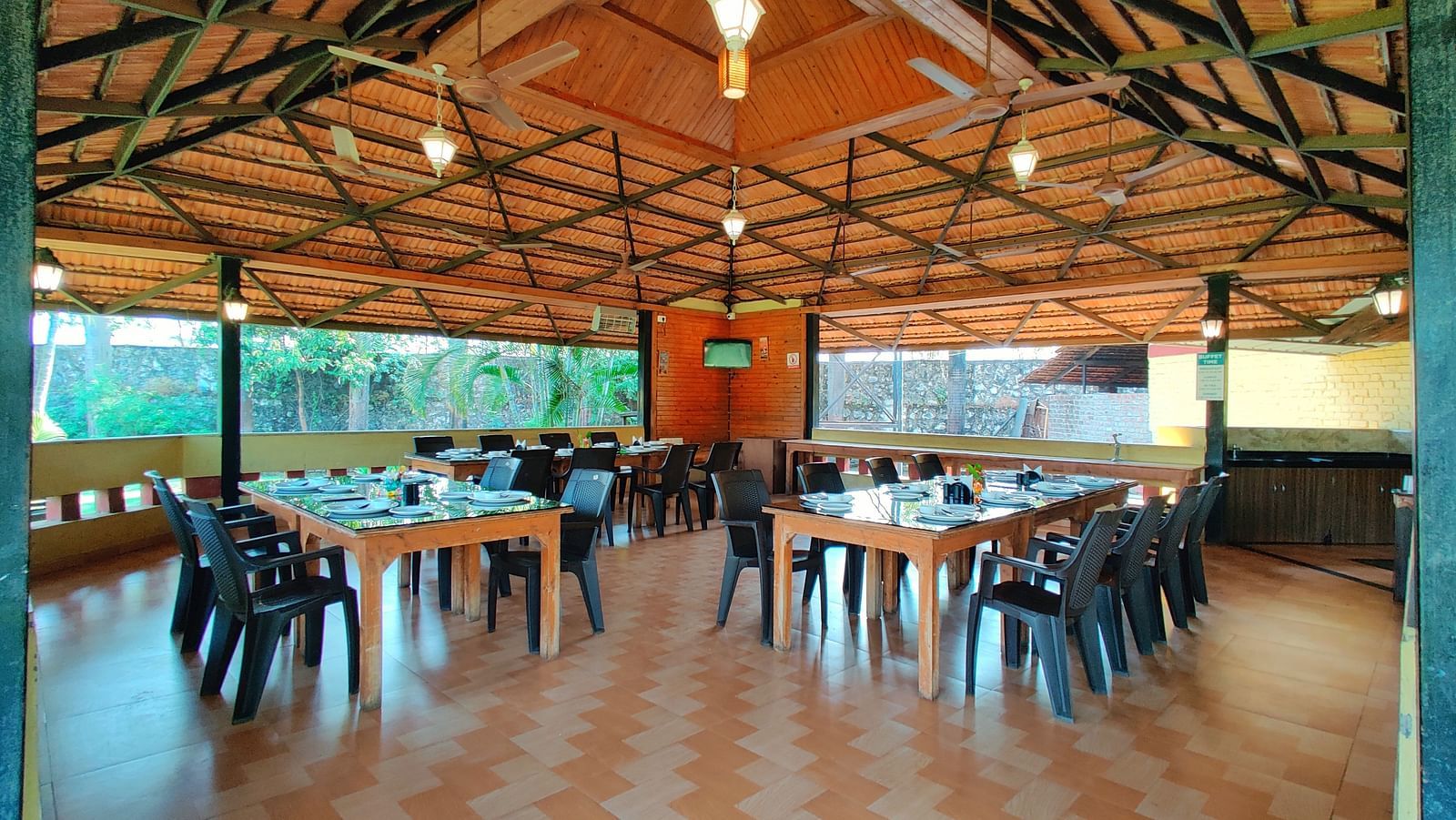 An empty outdoor dining area at The Kanila Resort with chairs and tables. 
