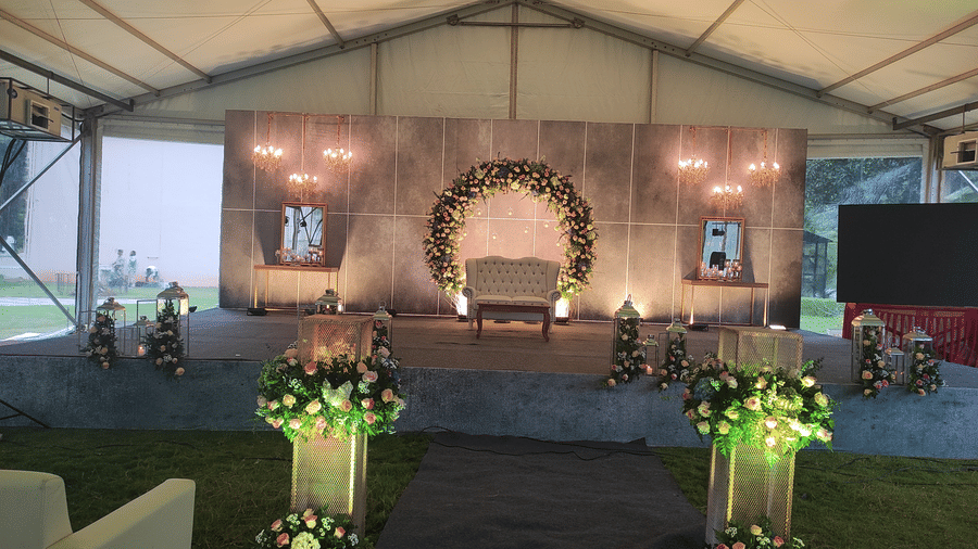 An event tent, focusing on the stage area with floral decorations, ready for a celebration or wedding - Black Thunder, Coimbatore